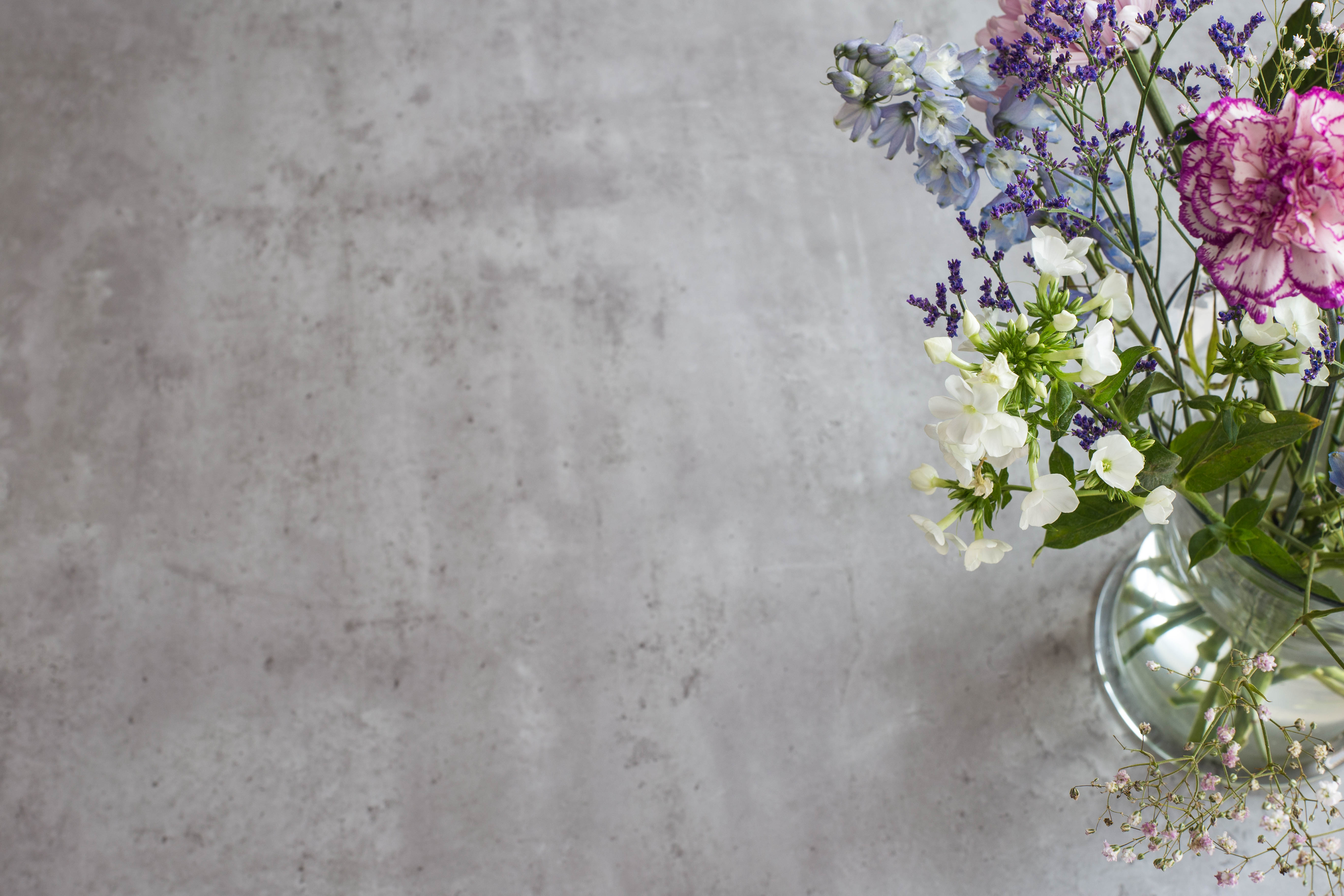 En vas med blommer som står på micorcement